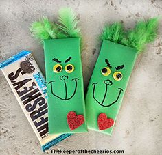 two green candy bags with faces on them next to a bag of hersheys