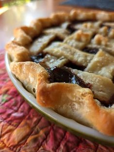 a close up of a pie on a plate with a red table cloth behind it