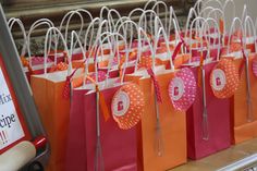 many bags are lined up on the counter with paper tags hanging from them and some scissors in front of them