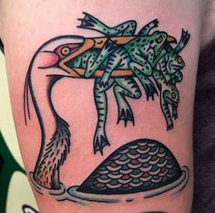 a colorful tattoo with an image of a bird and fish on it's arm