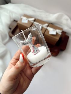 a person holding a glass with some decorations in it