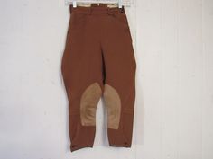 "Vintage 1950s jodhpurs, horse riding pants or motorcycle pants. Made of rust brown wool twill. Has a zip side, two waist pockets and button cuffs. Made by Brittany Riding Apparel. Size small or extra small. Actual measurements are: 21.75\" at the waist 37\" hips 18.5\" inseam 29.5\" overall length In good condition with some spots." Fitted Full-length Riding Pants, Fitted Breeches With Pockets For Fall, Fall Fitted Breeches With Pockets, Vintage Fitted Breeches With Pockets, Fitted Vintage Breeches With Pockets, Fitted Breeches With Belt Loops For Fall, Fitted Fall Breeches With Belt Loops, Fitted Vintage Brown Bottoms, Horse Riding Pants