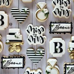 decorated cookies are arranged in the shape of hearts and wedding rings on a white wooden surface