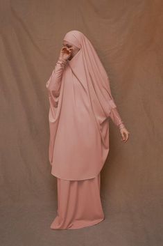 Introducing Pink Moira Prayer Umrah Gown with Niqab Feature from Annah Hariri. This beautiful gown is made from high-quality Nada abaya fabric and features super light, stretchy jersey sleeves for ultimate comfort. The elasticated waistband and full skirt ensure a flattering and secure fit, while the khimar can be tied at the back of the head for added coverage.But the best part? This gown can also be transformed into a niqaab with just a few simple stitches. So whether you're performing Umrah, Abaya Fabric, Annah Hariri, Gown With Sleeves, Modest Activewear, Full Coverage Swimsuit, Modest Maxi Dress, Modest Maxi, Back Of The Head, Abaya Dress