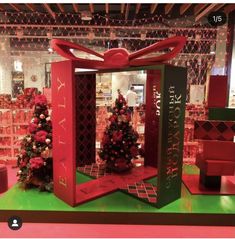 a christmas display in a store with red and green boxes on the floor, decorated for holiday