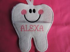 a tooth shaped ornament with a smile on it's face and name