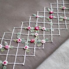 a close up of a cloth with flowers and vines on the side, attached to a piece of fabric