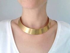 So chic and sleek. Add some oomph to your look with this simple but super elegant choker. The gold tone choker looks great on any complexion and is an eye-catching statement piece that anyone can pull off ! The model has a neck circumference approx 15 inches. The choker has a circumference approx 14 inches. One size, fit most. The choker comes without clasp. Contains no lead or nickel. Do not perfume over it or subject it to any liquid substances. I love the pure metal. But over time, metal will African Choker, Elegant Choker, Gold Collar Necklace, Bib Collar, Boho Choker, Statement Choker, Neck Choker, Gold Collar, Gold Choker Necklace