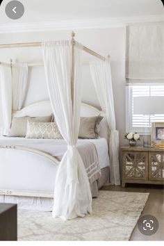 a white bed sitting in a bedroom next to a window