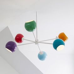 a multicolored chandelier hanging from the ceiling in a room with white walls