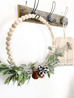 a wooden beaded wreath hanging on a wall next to a wood sign with an acorn and pinecone decoration