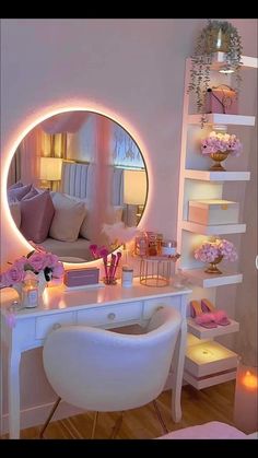 a white desk topped with a mirror next to a chair and a shelf filled with pink flowers