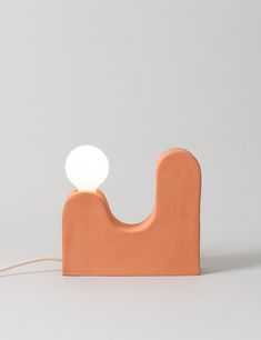 an orange wooden lamp with a white light on it