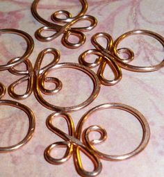 several pieces of metal sitting on top of a pink tablecloth covered in swirls