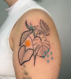 a woman's shoulder with flowers and leaves on it