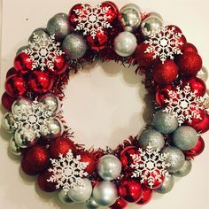 a christmas wreath with silver and red ornaments