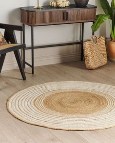 a room with a table, chair and rug on the floor