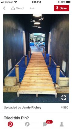 an image of a long wooden walkway going up the side of a building with blue carpet