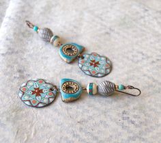 "Exquisite earrings featuring blue enameled mandala charms that look like flowers. These bohemian dangle below blue ceramic components, stone inlaid bone beads, copper spacers, rustic artisan ceramic beads and turquoise blue magnesite beads. These finely detailed earrings dangle from hypo-allergenic niobium earring hooks and measure 3 3/8\" in total length. Return to shop: bstrung.etsy.com More links where you can find me: Facebook: http://www.facebook.com/bstrung Pinterest: http://pinterest.com Bohemian Enamel Pierced Jewelry, Bohemian Enamel Jewelry, Bohemian Enamel Earrings Nickel Free, Bohemian Enamel Earrings Nickel-free, Artsy Blue Metal Jewelry, Nickel-free Bohemian Enamel Earrings, Bohemian Blue Enamel Earrings, Artsy Blue Enamel Jewelry, Handmade Turquoise Enamel Earrings