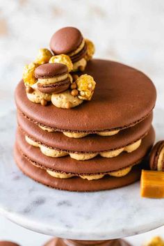 a stack of cookies on top of a cake plate with chocolate and macaroni