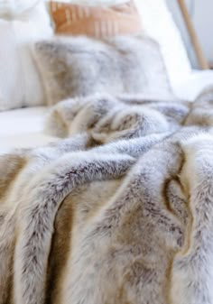 a bed with white and grey fur on it