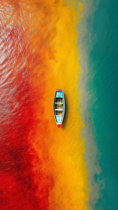 a boat floating on top of a body of water next to a rainbow colored wall