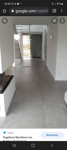 an empty living room with white walls and flooring is seen in this image from the hallway