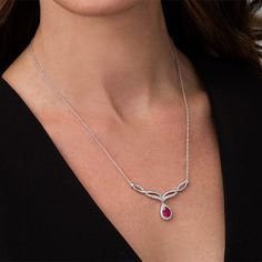 Classic and sophisticated, this fashion necklace flows with easy elegance. Crafted in sterling silver, this exquisite style shimmers with an 8.0 x 5.0mm pear-shaped lab-created bright red ruby dangle framed with sparkling petite lab-created white sapphires - all beneath an attractive chevron-shaped twist of polished and created sapphire-lined ribbons. Buffed to a brilliant luster, this design suspends centered along an 18.0-inch rope chain that secures with a spring-ring clasp. Elegant Silver Necklace With Lab-created Ruby, Luxury Silver Ruby Necklace, Silver Necklace With Gemstone And Lab-created Ruby, Elegant Lab-created Ruby Pendant Jewelry, Red Gemstone Pear-shaped Necklace, Chevron Necklace, Peoples Jewellers, Rope Chain, White Sapphire