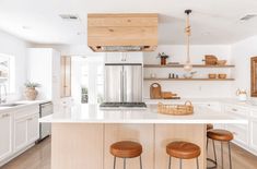 a kitchen with two stools next to an island