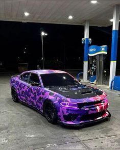 a purple camo car parked in front of a gas station