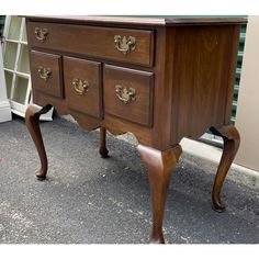 an old wooden desk with two drawers on it