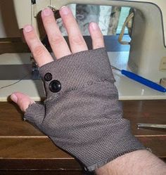 a person's hand wearing a pair of gloves next to a sewing machine