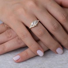 a woman's hand with a diamond ring on her finger and two other hands