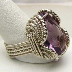 "Wire Wrapped Sterling Silver Handmade Genuine Faceted Amethyst Ring 25x18mm 12+ct View more Amethyst jewelry in our shop https://www.etsy.com/shop/JandSGems?ref=hdr_shop_menu&search_query=amethyst Sizing and shipping is ALWAYS FREE with a 14 day \"No Questions Asked\" return policy. This ring is made with real gems. I made it myself, so if you see a setting you like and want a different gem in it, I can put in another one as they are not finished. I can probably do it for the same price or Elegant Silver Wire-wrapped Crystal Ring, Elegant Silver Wire Wrapped Crystal Ring, Exquisite Silver Amethyst Ring, Handmade Elegant Amethyst Crystal Ring, Elegant Wire Wrapped Crystal Ring For Wedding, Handmade Purple Amethyst Ring In Fine Jewelry Style, Handmade Purple Amethyst Ring Fine Jewelry, Elegant Wire Wrapped Crystal Ring For Anniversary, Handmade Purple Amethyst Ring