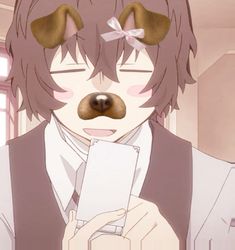 an anime character with brown hair holding a cell phone in his right hand and looking at the camera