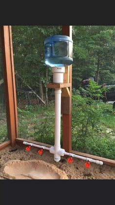 a water dispenser on the side of a window sill in an enclosure