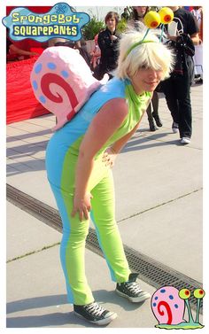 a woman in a costume is standing on the sidewalk