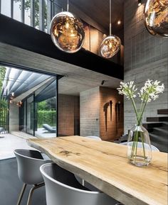 a dining room table with chairs and lights hanging from the ceiling