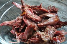 a glass bowl filled with meat sitting on top of a table