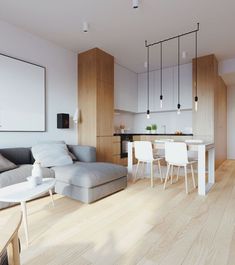 a living room filled with furniture next to a kitchen and dining area on top of a hard wood floor