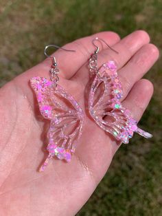 Each pair of earrings are handmade to order, therefore no two pairs are identical! However, I try to get as close as possible :) Hypoallergenic & nickel-free sterling silver plated fishhook earrings. Each butterfly wing is approximately 2 inches in length and are made with epoxy resin, iridescent pastel pink glitter, & holographic glitter ✨  These dangly sparkly resin butterfly earrings are perfect for any occasion! Color may vary slightly. Thanks for visiting my shop! 💕 Other color options are Pink Fashion Accessories, Pink Butterfly Earrings, Cute Clear Dangle Earrings, Whimsical Hypoallergenic Party Earrings, Cute Pink Glitter Earrings, Cute Butterfly-shaped Jewelry For Parties, Unique Iridescent Earrings For Party, Whimsical Handmade Earrings For Party, Pink Whimsical Pierced Earrings