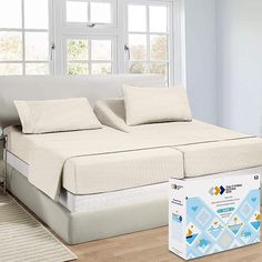 a bed with two pillows on top of it and a box in front of it