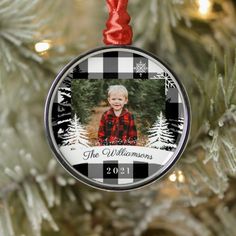 a christmas ornament hanging from a tree with a photo in the center and snowflakes on it