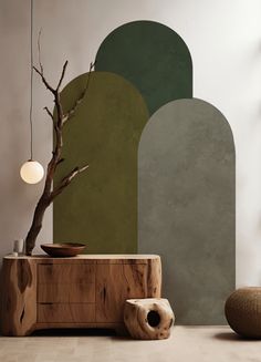 a wooden table sitting in front of a green and grey wall with a vase on it