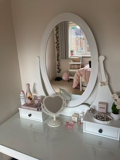 a mirror sitting on top of a white dresser