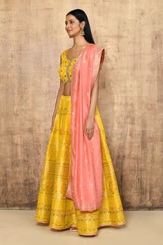 Yellow brocade silk lehenga with an attached cancan and floral pattern. Comes with a padded blouse and a pink dupatta. - Aza Fashions Transitional Anarkali Choli, Tissue Silk Dupatta For Navratri, Silk Lehenga With Pallu, Tissue Silk Sets For Reception, Brocade Sharara With Pallu, Sleeveless Silk Lehenga With Dupatta, Raw Silk Sets With Sheer Dupatta, Transitional Anarkali Set With Tilla Details, Transitional Season Anarkali Set With Tilla