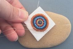 a person is stitching something on top of a rock