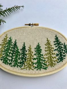 a cross stitch pattern with pine trees on it