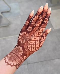 a woman's hand with henna tattoos on it