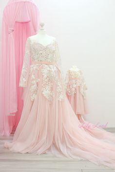 a pink dress with white flowers is on display in front of a mannequin